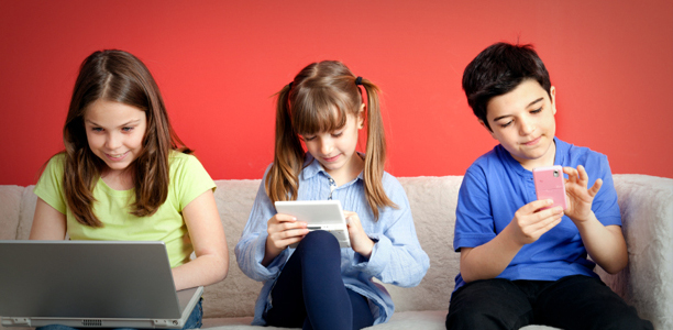 niños delante de diferentes dispositivos electronicos