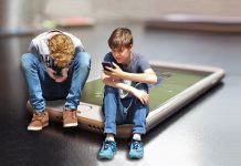 dos adolescentes usando sus dispositivos móviles. De fondo un smartphone
