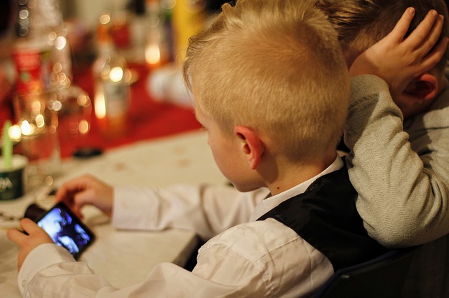 Un niño pequeños haciendo uso de un smartphone.